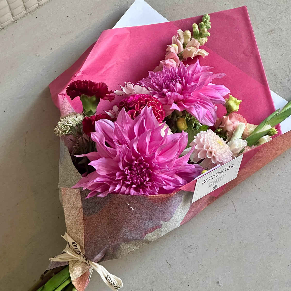 Le Passionné : dahlias fuchsia, célosie rouge et œillets, emballage rose vif - Bouquetier Paris 17