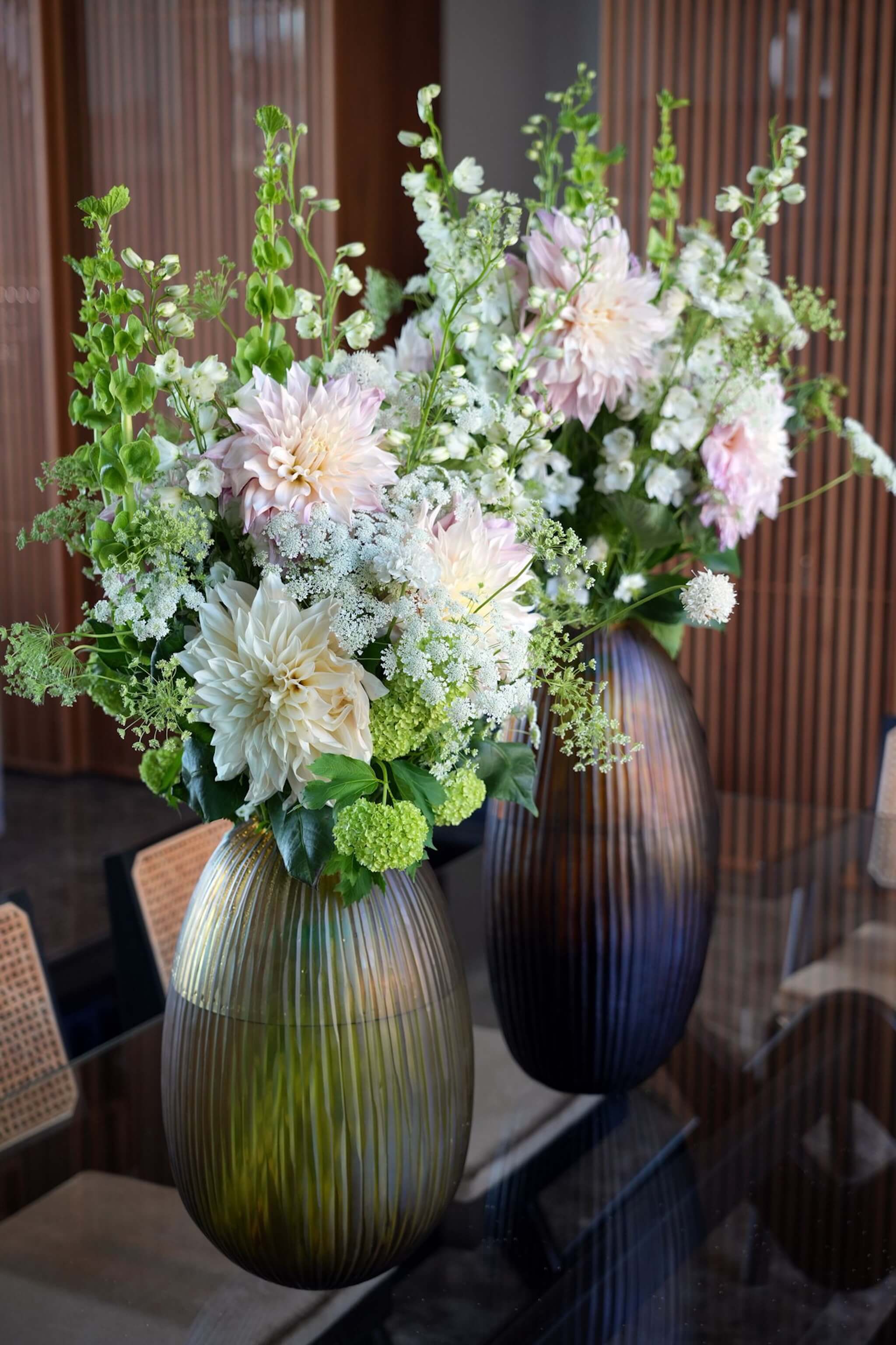Compositions de fleurs de saison aux tons clairs, disposées dans des vases