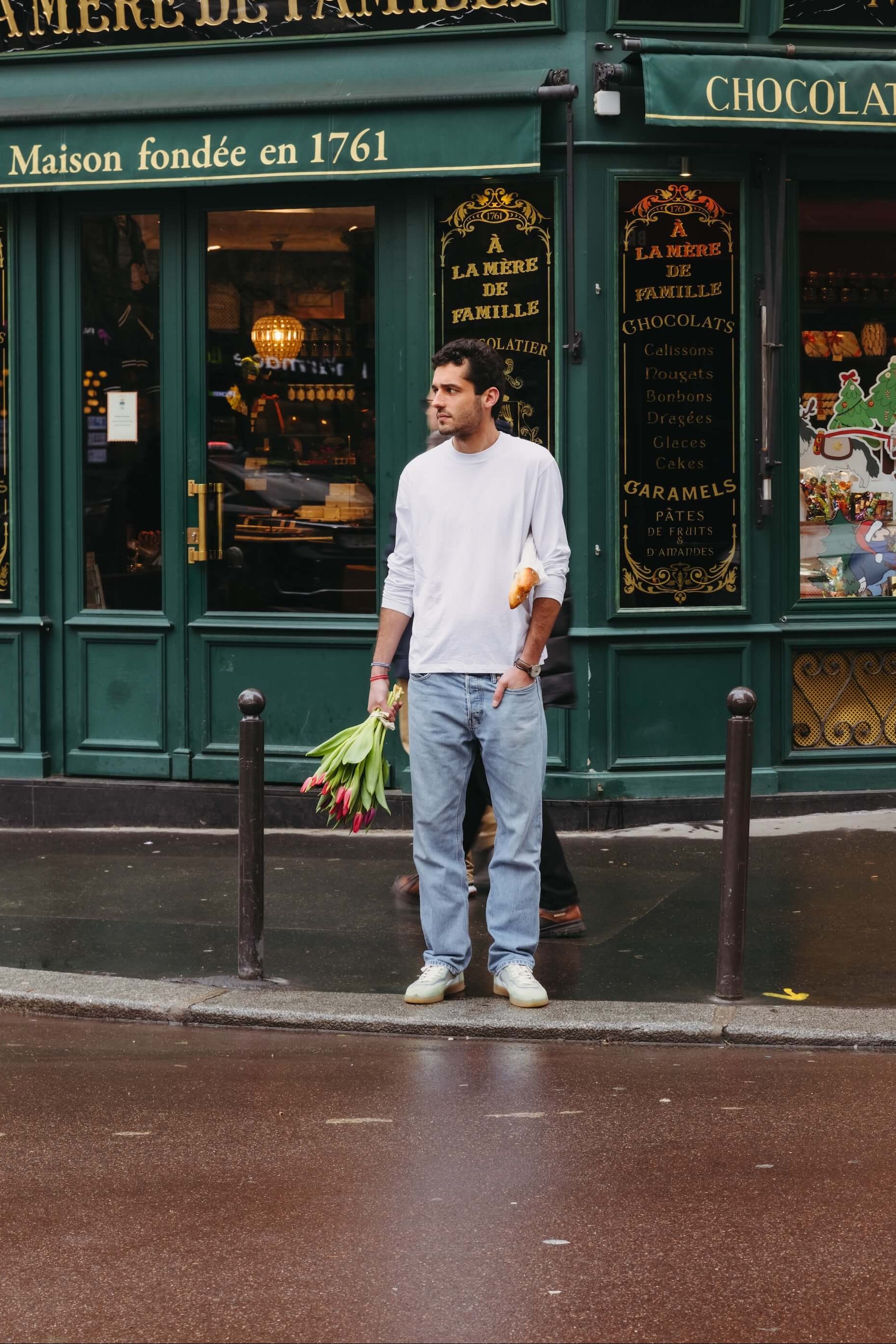 Personne tenant un bouquet de fleurs de saison lors d’une course dans une rue parisienne