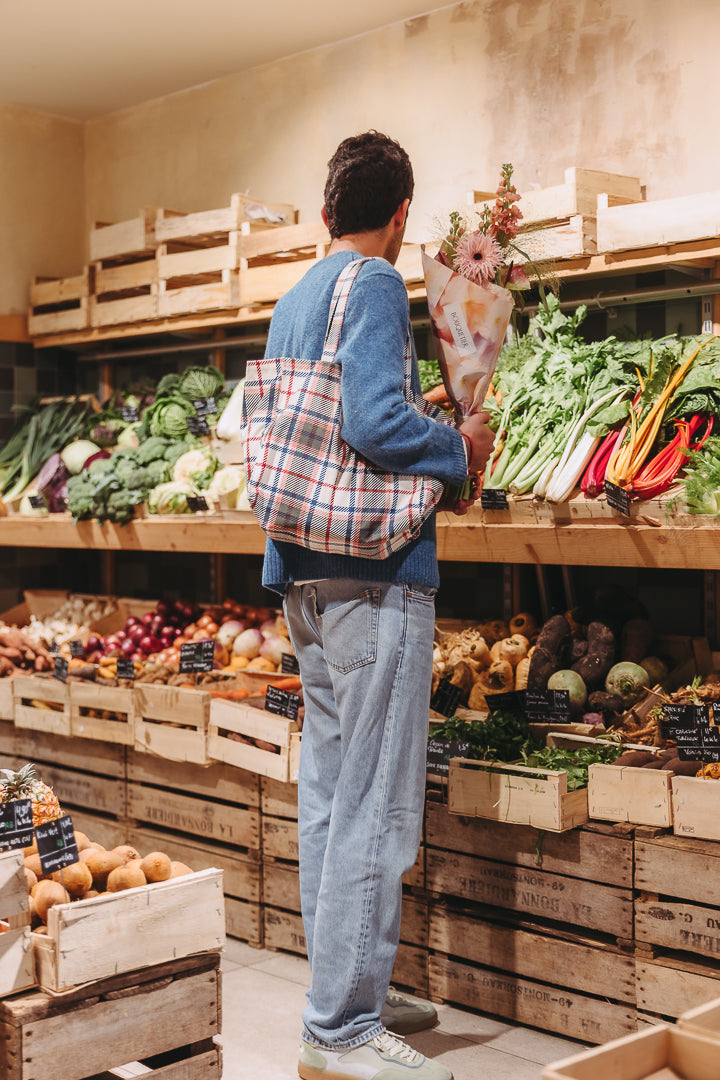 Personne faisant ses courses avec un bouquet de fleurs de saison
