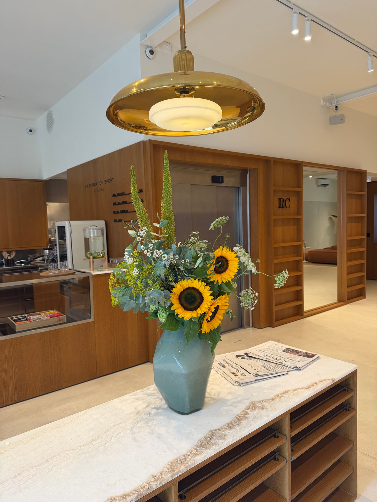 Composition de tournesols et fleurs bordeaux dans un vase en ceramique blanche, par Bouquetier Paris 17