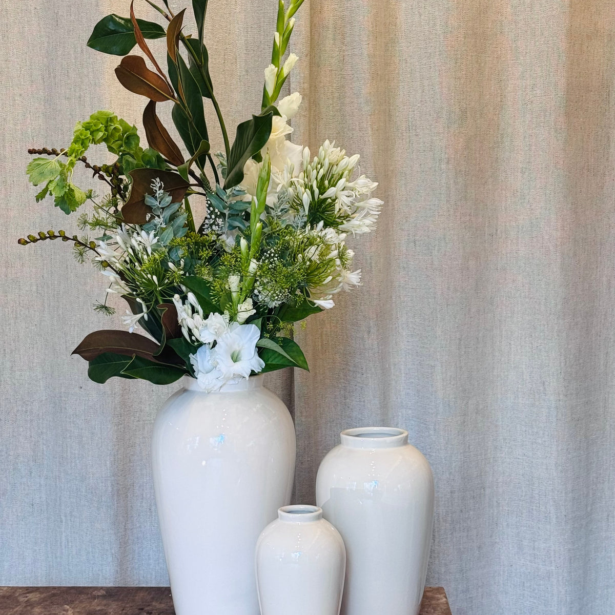 Le Végétal, agapanthes et glaïeuls blancs, feuillages verts dans vase en céramique blanc - Bouquetier Paris 17