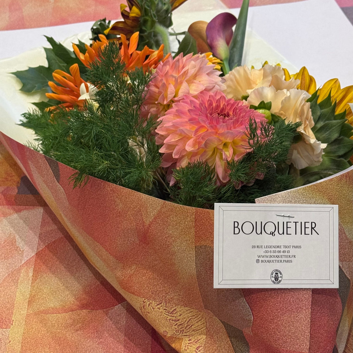 Le Solaire, dahlias roses et oranges, gerberas jaunes et feuillage d'aneth dans papier kraft - Bouquetier Paris 17