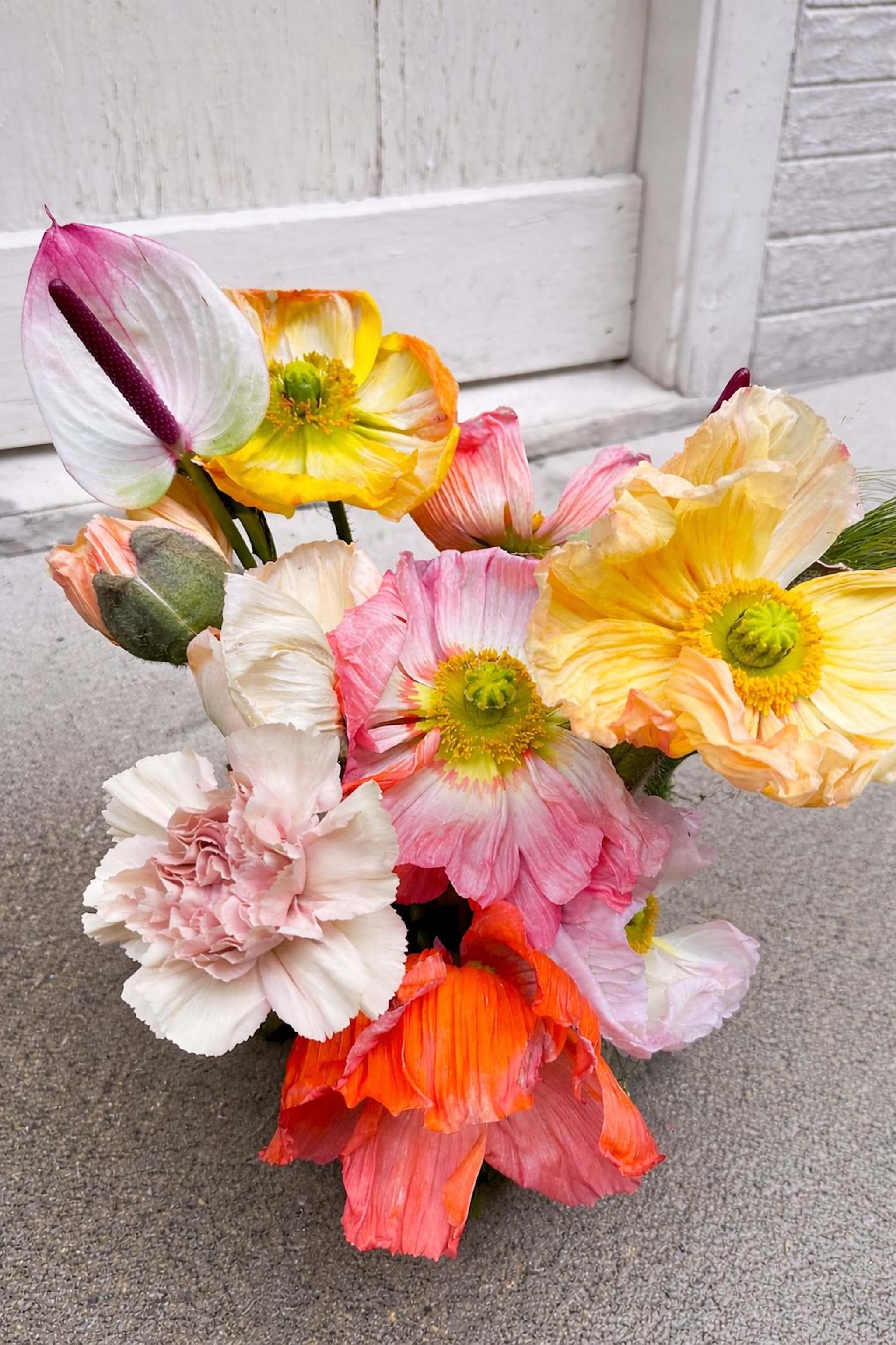 Bouquet de fleurs de saison aux teintes rose, orange et jaune