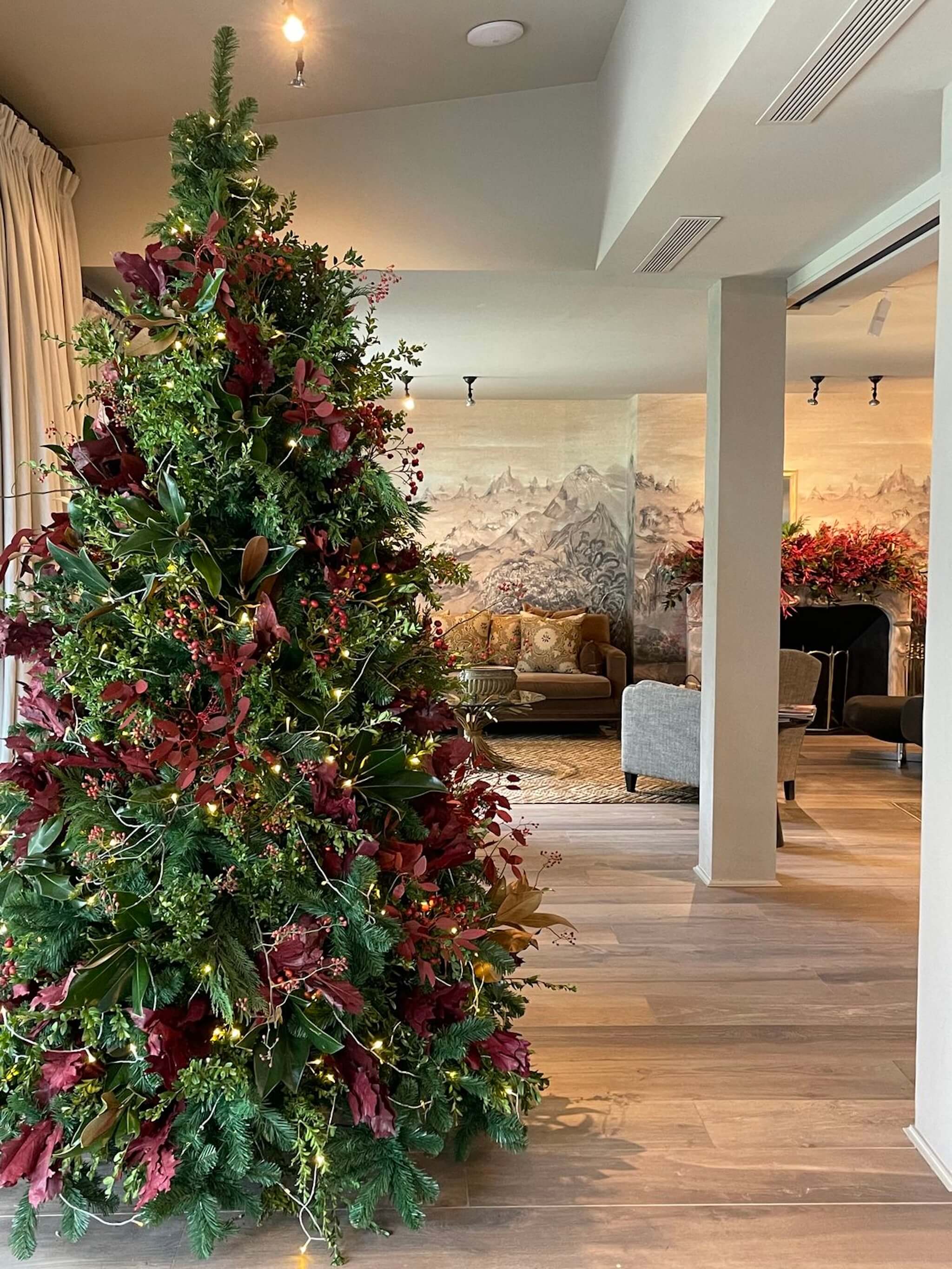 Installation florale de Noël composée de feuillages et fleurs, en intérieur